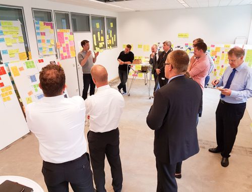Kunden bei einem Design Thinking Workshop hören dem Kursleiter zu